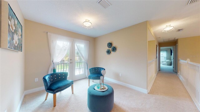 living area featuring french doors and light colored carpet