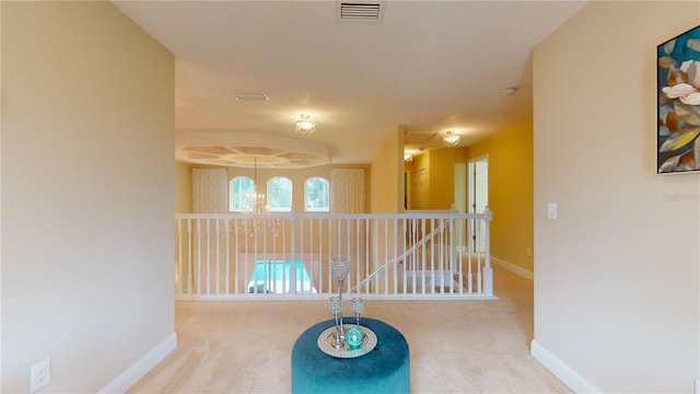 corridor featuring carpet floors, an upstairs landing, visible vents, and baseboards