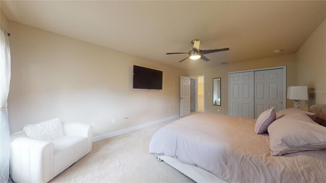 bedroom with ceiling fan, carpet, and a closet