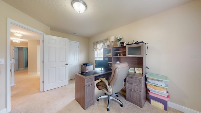 office area featuring baseboards, visible vents, a textured ceiling, and light colored carpet