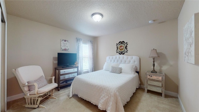 bedroom with baseboards, a textured ceiling, and light colored carpet