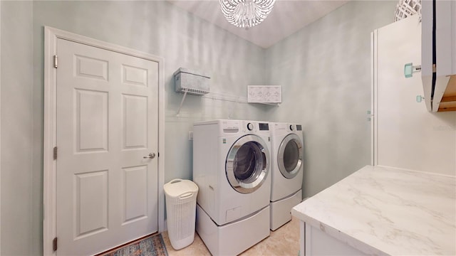 laundry room featuring laundry area, washing machine and clothes dryer, and an inviting chandelier