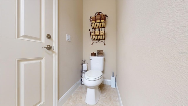 bathroom featuring tile patterned floors, toilet, and baseboards