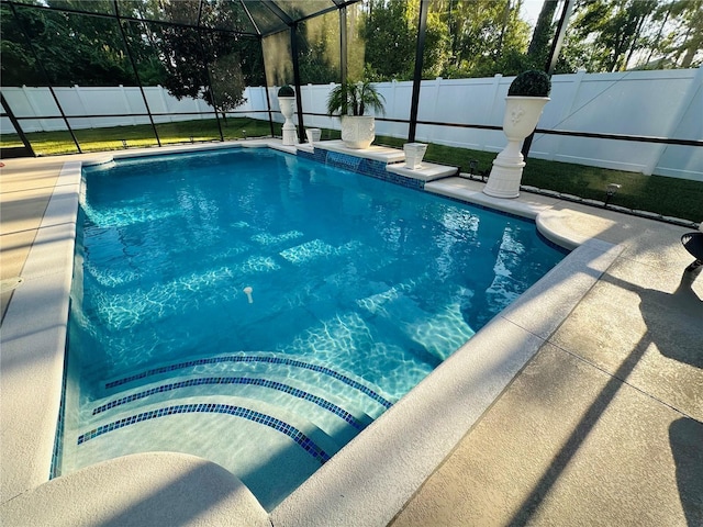 view of swimming pool with glass enclosure, a patio area, a fenced backyard, and a fenced in pool