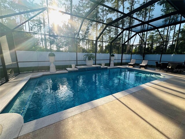 view of swimming pool with a patio area and a lanai