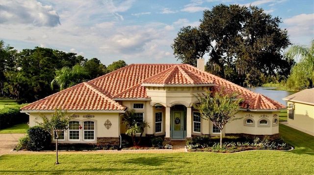 mediterranean / spanish home featuring a water view and a front yard