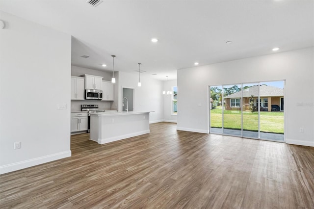 unfurnished living room with wood-type flooring and sink