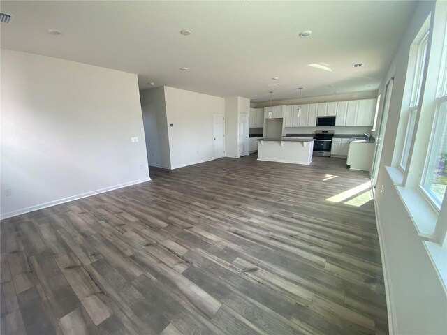 unfurnished living room featuring dark hardwood / wood-style floors and sink