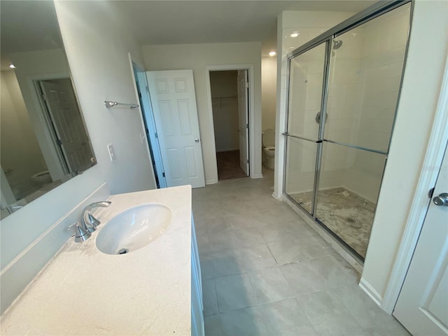 bathroom with tile patterned floors, vanity, toilet, and an enclosed shower