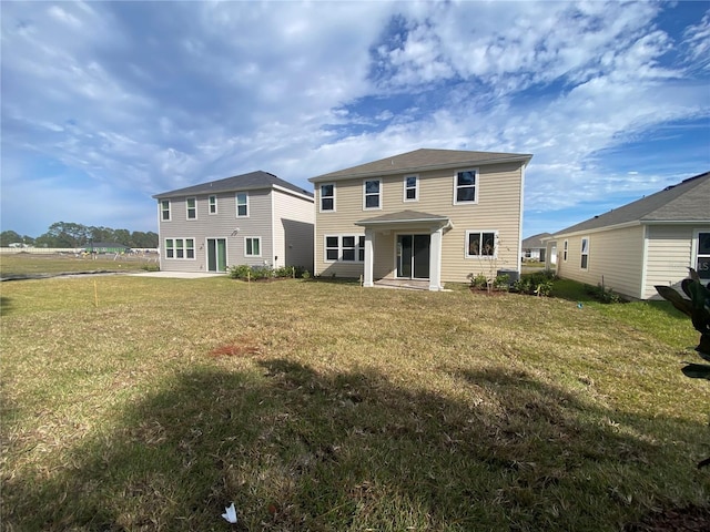 rear view of house featuring a lawn