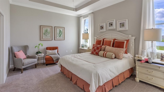 bedroom with a tray ceiling, ornamental molding, and light colored carpet