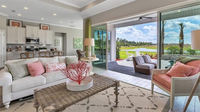 living area featuring a ceiling fan, recessed lighting, visible vents, and crown molding