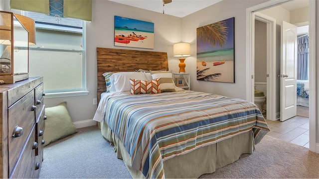 bedroom with light colored carpet and ensuite bathroom