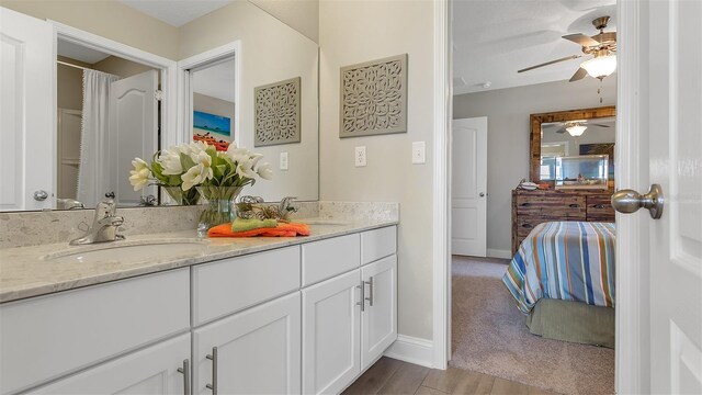 bathroom featuring ceiling fan, hardwood / wood-style floors, and vanity