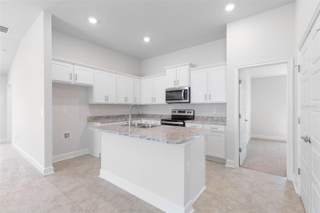 kitchen featuring sink, appliances with stainless steel finishes, light carpet, white cabinetry, and a center island with sink