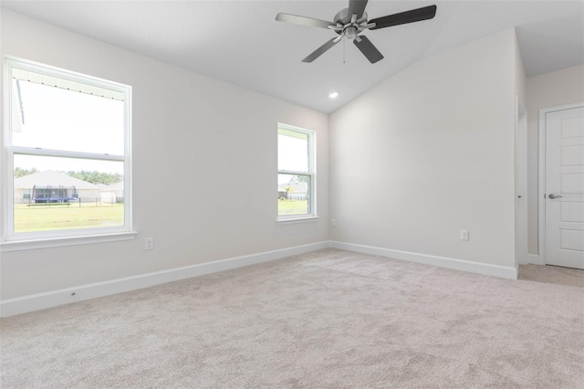 unfurnished room featuring light carpet, ceiling fan, lofted ceiling, and baseboards