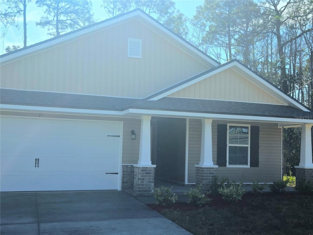 craftsman house featuring covered porch, driveway, a shingled roof, and a garage