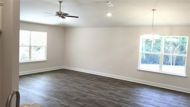 unfurnished room featuring a wealth of natural light, dark wood-style flooring, visible vents, and baseboards