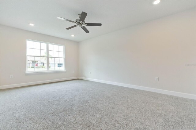 carpeted spare room featuring ceiling fan