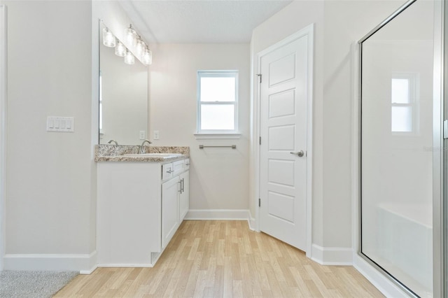 bathroom with an enclosed shower, hardwood / wood-style flooring, and vanity