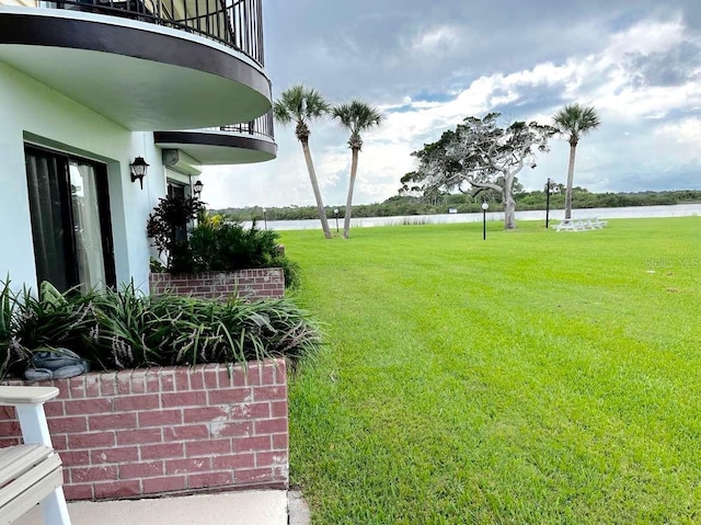 view of yard with a water view and a balcony