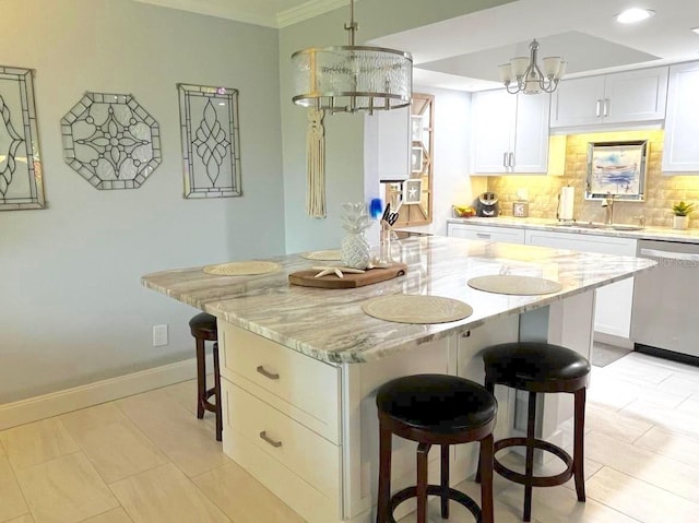 kitchen featuring a breakfast bar, decorative backsplash, stainless steel dishwasher, a sink, and a chandelier