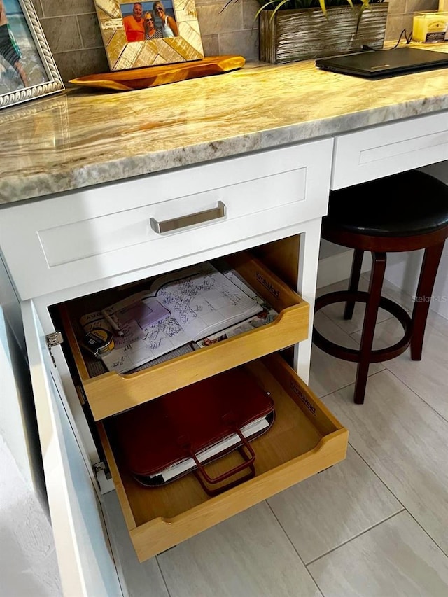 room details featuring backsplash and white cabinetry