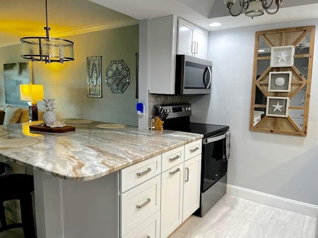 kitchen featuring light stone counters, a notable chandelier, stainless steel appliances, white cabinetry, and baseboards