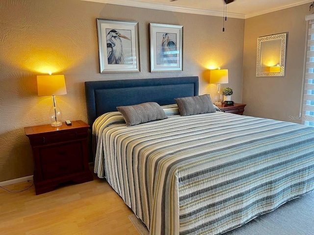 bedroom with light wood-style flooring and crown molding