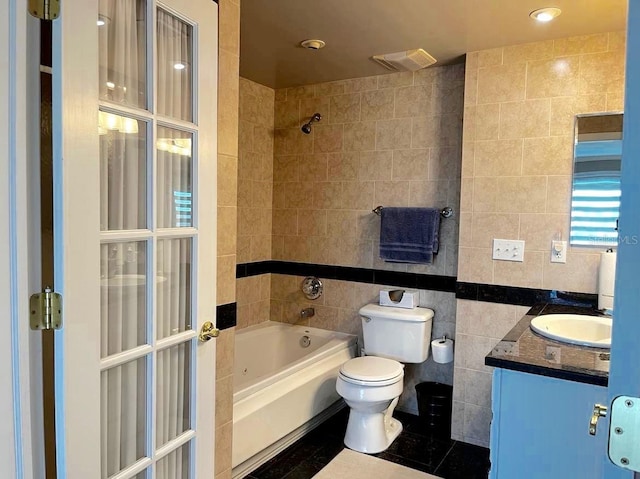 bathroom featuring bathing tub / shower combination, toilet, tile patterned floors, vanity, and tile walls