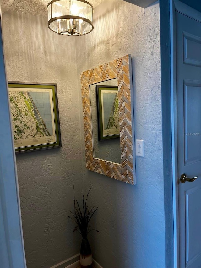 room details featuring a notable chandelier and a textured wall