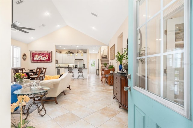 interior space with a ceiling fan, visible vents, high vaulted ceiling, and light tile patterned floors