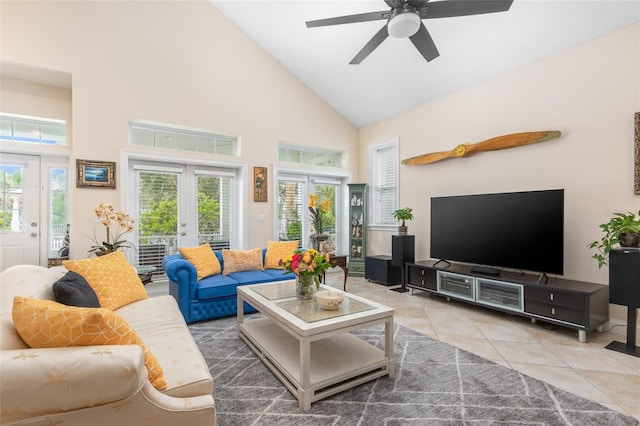 tiled living area with plenty of natural light, high vaulted ceiling, a ceiling fan, and french doors