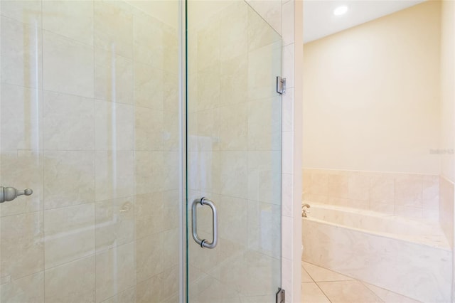 bathroom with a stall shower, a garden tub, and recessed lighting