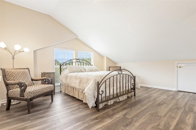 bedroom with lofted ceiling, wood finished floors, and baseboards