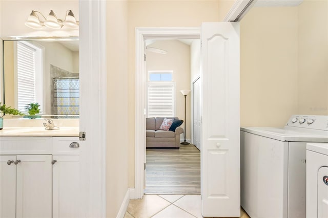 washroom with laundry area, light tile patterned flooring, plenty of natural light, and washer and clothes dryer