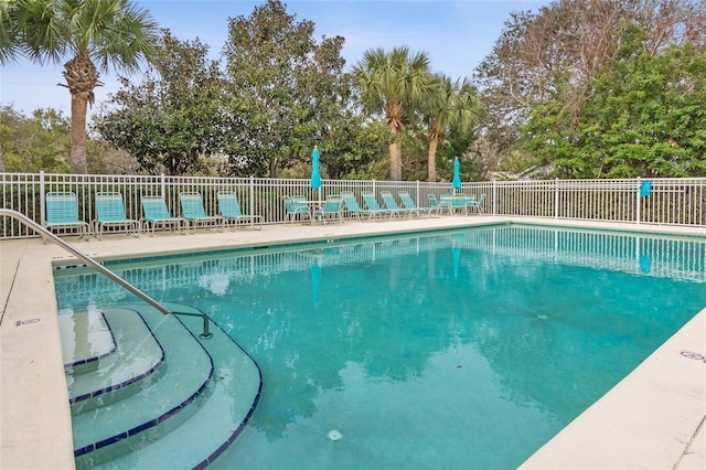 pool with a patio area and fence