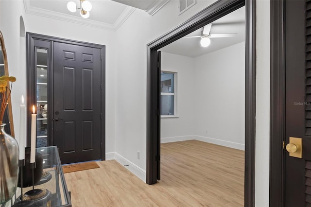 foyer with ceiling fan, crown molding, and hardwood / wood-style flooring