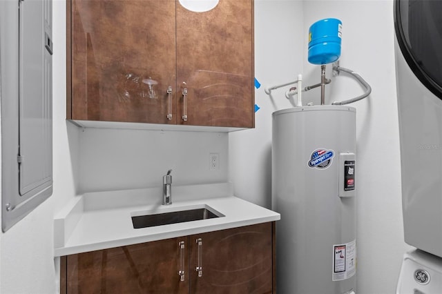 laundry room featuring cabinet space, a sink, and electric water heater