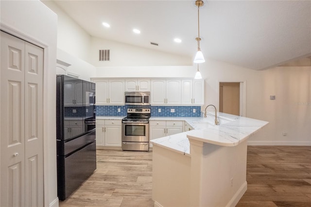 kitchen featuring kitchen peninsula, stainless steel appliances, white cabinets, and hanging light fixtures