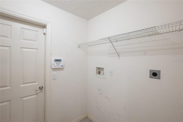 clothes washing area with a textured ceiling, hookup for a washing machine, and electric dryer hookup