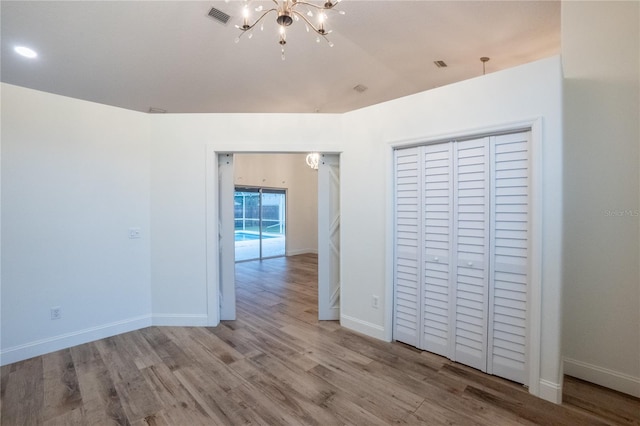 interior space with lofted ceiling, a notable chandelier, and light hardwood / wood-style floors