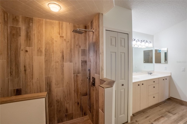 bathroom featuring wood-type flooring, walk in shower, and vanity