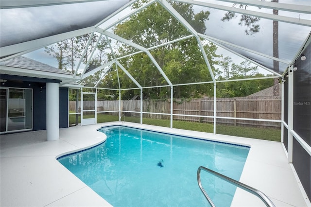 view of swimming pool featuring glass enclosure and a patio area