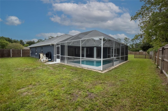 rear view of property with glass enclosure, a fenced in pool, a lawn, and a patio