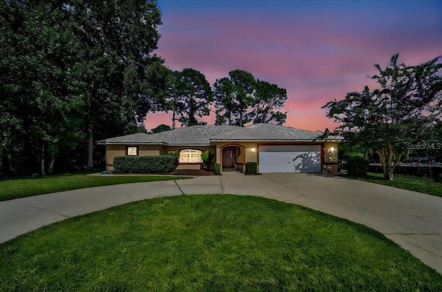 ranch-style home with concrete driveway, a front lawn, an attached garage, and stucco siding