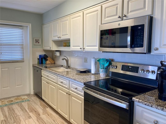 kitchen with light wood-type flooring, white cabinetry, stainless steel appliances, and sink