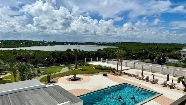 view of pool with a water view and a patio