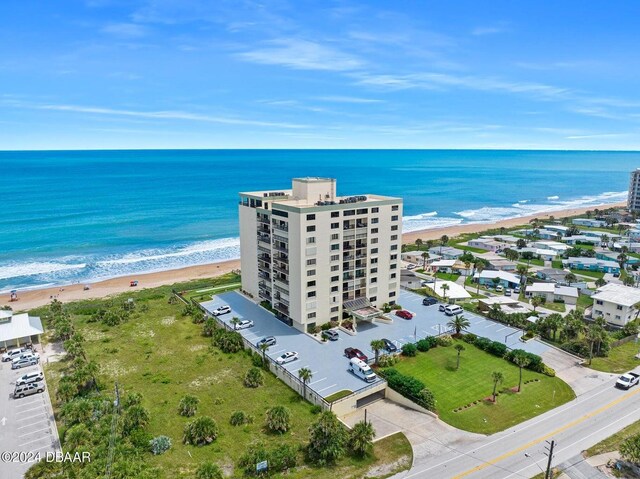 drone / aerial view featuring a water view and a beach view