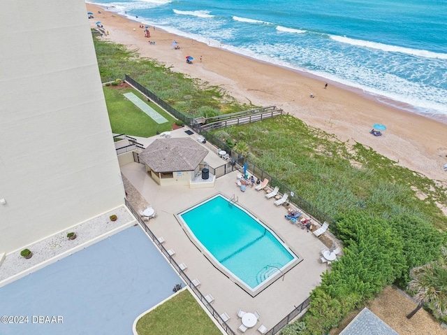 birds eye view of property featuring a water view and a beach view